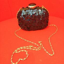 Ladies Clutch bag with Royal Blue sequins on both sides. The shoulder chain is silver effect. The bag opens with a silver circular catch which has a beautiful black crystal stone on top. The bag measures 5in long X 4in tall X 2in depth. Bag clasp is in good working order.