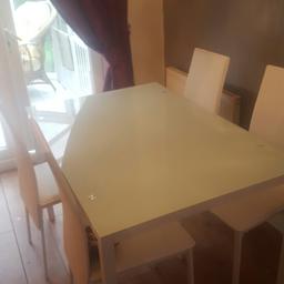 Glass table with 4 white leather effect chairs excellent condition.