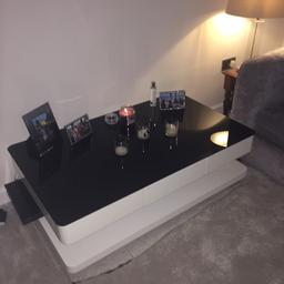 Modern gloss white coffee table with matt black glass on top. (Glass is removable) One drawer - as shown in picture.

Sizes: 121cm L x 71cm W x 36cm H

Couple of cosmetic blemishes on the glass and small crack on the side of base.

Purchased new 12 months ago for £150 - will be sad to see it go!