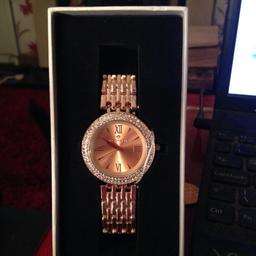 Bought in the sale but never wore it. Rose gold with diamontes around the face. Still has the cover over the dial to change the time. Perfect xmas present for someone