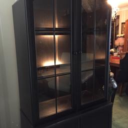 Black wooden display cabinets with lights .
The Top cabinets have glass doors with a cupboard below for more storage .
Buyer to collect.