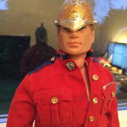 Action Man 1964 by Palitoy in Army Dress Uniform. Blonde real hair effect with blue eyes. Fixed plastic hands so an excellent early example. Complete with tunic, trousers, boots and helmet. Highly collectable.