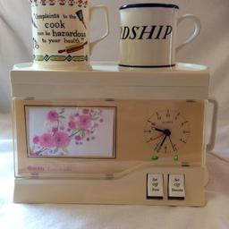Tea Maker and Clock Alarm in One. Compact Bedside Design, Flat Lid for cups/mugs (mugs not included). Place your own photo in the area showing pink flowers.
Collection only.