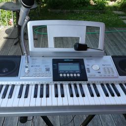 Elektrisches Keyboard C. Giant mit Mikrofon und dazu passenden Ständer. Spielt verschiedene Instrumente als Begleitung dazu. Fast neu.