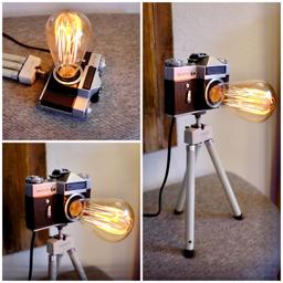 Zum Angebot steht eine wunderschöne Kameralampe aus einer alten Zenith (Revueflex) Spiegelreflexkamera.

Sie steht auf einem alten ausziehbaren Monaco Stativ und ist bestückt mit einer dimmbaren Vintage Edison Glühbirne (Filament) in Tropfenform sowie einem Netzkabel mit ein/Aus-Schalter und stufenlosem Dimmer!

Im Preis enthalten ist die komplette Lampe wie abgebildet inkl.:

- Kamera
- Stativ
- Edison-Glühbirne
- Kabel mit Schalter und stufenlosem Dimmer.

Sie können sie also sofort aufstellen