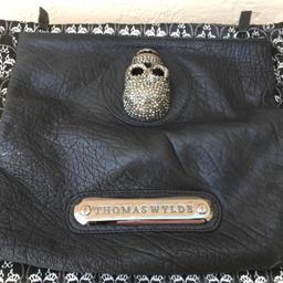Not free, offers please ( THOMAS WYLDE CRYSTAL EMBELLISHED SKULL  FOLD OVER BLACK CLUTCH BAG W/DUST BAG), amazing bag in soft wrinkled luxurious leather, huge skull completely covered with studs, signature skull lining, a fabulous bag, 10X11  UNFOLDED AND 5.5 X 11 FOLDED, a must have !! This bag is a major designer in US and they are selling for $200 on eBay as seen in attached picture. The bag comes with its own dust bag. Missing 3 stones as you can see in the picture.