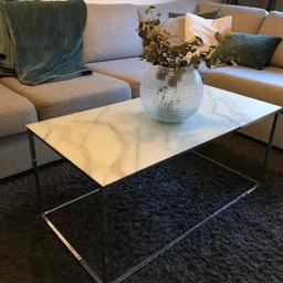 Soffbord med skiva i vitt marmormönstrat glas och underrede i kromad metall. Mått: L100 B50 H45 cm.

Köpt för 2000, säljer för 800.1 år gammalt i fint skick.