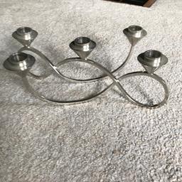 Silver candle holder with space for 5 tapered candles 

Swirl linked design... originally from Debenhams 

Will post for additional cost