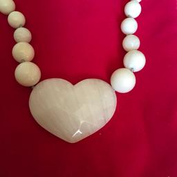 Lovely creamy white heart shaped pendant on round beaded necklace. Never worn.