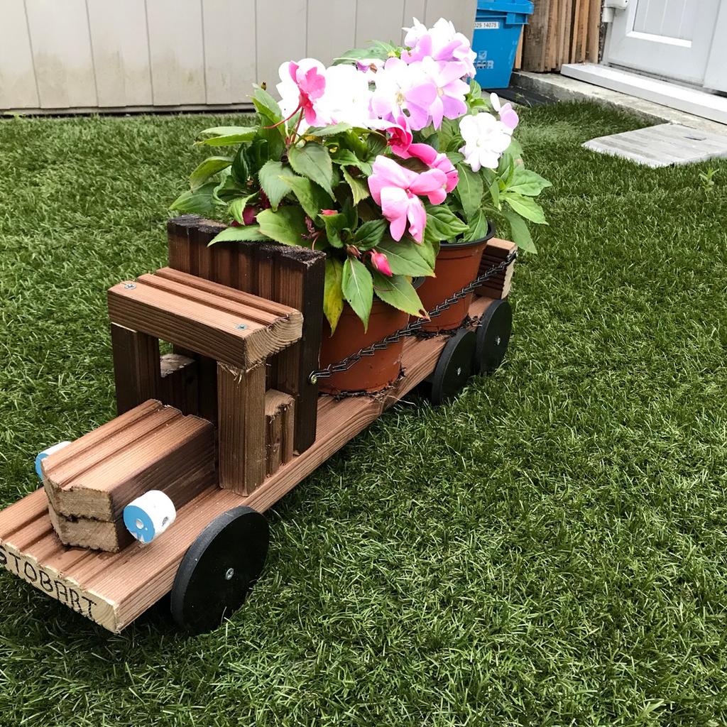Home made garden lorry will hold 2 large or 3 small plant pots made from treated decking board 23inch long by 5 inch wide
Plants not included
