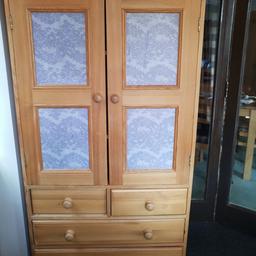 A solid pine cabinet with two shelves in the cupboard, and four drawers. Small left hand drawer needs small fix (slides too far into cabinet). Purple decoupage to door fronts is easily removable. Some pin holes and general wear marks. Needs some TLC, ideal for upcycling. 83cm wide by 165cm high.