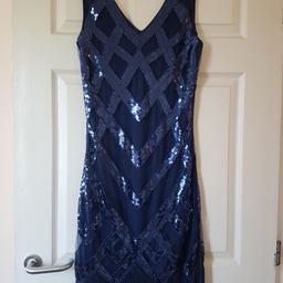 Lovely 1920s style dress in navy blue, comes with headband and beads. Worn once for fancy dress. (Please note the tassles have a tendency to fray given the material) the dress itself is lovely. Size 12.