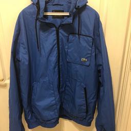 Blue Lacoste zip jacket with zip front pocket and a hood that can be put away. Plus 2 other zipped pockets to the front All my clothes are like new so you won’t be disappointed.