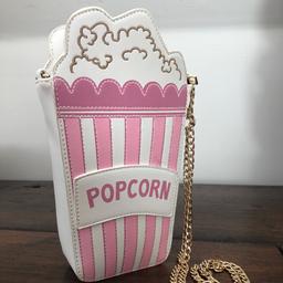 Very cute pink and white, “leather” feel, novelty popcorn-box shaped cross body bag, with gold chain and zipped interior.
Excellent condition.