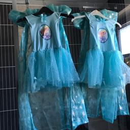 Here is two lovely bespoke frozen dress outfits. The dresses were my little granddaughters, I made the sparkly cloaks with high ruffle collars. The girls loved them. There is a stretchy bodice with Elsa & Anna on the front. There is a netted lates skirt with bows on the bottom. Then there is the sparkly cloak with a large frill collar. The dress fits one Size roughly age 3-7years. Excellent con and freshly laundered. Would make any little girl happy.if you only want one, let me know.