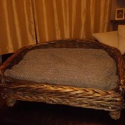 wicker basket pet bed with removable padded cushion for washing. can easily fit 2 cats or small breed dog. size approx 26" length, 20" depth (roundest point on back) 14" height (taken from highest point at back which includes the feet on the basket)  collection Knuzden Blackburn £6
