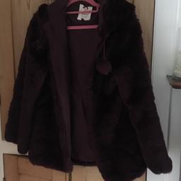 Faux fur coat. Dark purple. Size XS. With pom poms and a hood. Rarely worn and in excellent condition. Non smoking household.