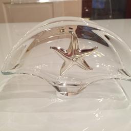 Portacarte in vetro con stella laminata in argento con cristallo al centro. 
Dimensioni: lunghezza 12 cm, altezza 7 cm.