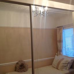 I am selling a double mirror sliding door wardrobe H 88inches L 79 inches D 26 inches ,these are the best pics I could get as the room is small , these are in good condition apart from1 of the mirror doors on the bottom is slightly damaged , and the side of the wardrobe has a few screw marks in it were a shelf was attached , I have added pics to show this hence the price it's on sale for