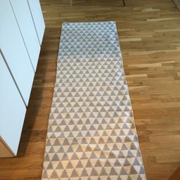 2,5 m lång 70cm bred matta med grå/lila/blå trekanter. Kan behövas en tvätt i maskin. Finns i Midsommarkransen, Telefonplan