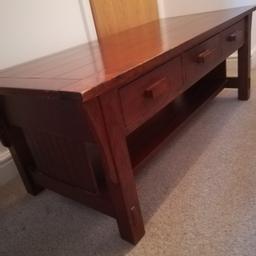 Dark wood coffee table, three drawers and lower shelf. Solid and heavy. Small hip on front left corner.4ft long by 22ins wide