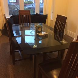 Glass table and 4 dark wood and black leather chairs. Very good condition, still got fire tags on chairs. Must collect and dismantle. Quick sale needed.