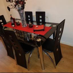 I have this beautiful glass table and chairs in black and silver. It is quite heavy and in great condition. The legs come off the table top and the chairs do not stack as they all have a long back.
The table top has a shelf built in to store things ie plate mats.
It is a beautiful table but too big for my needs.