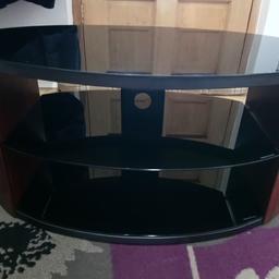 Black glass and walnut effect wood tv stand/ coffee table, In used very good condition with there glass shelves.
There is a back metal piece for the wires to go through, this can be taken off so it can be used as a coffee table aswell.
sizes H 16"inches, W 31.5 inches, Depth 17.5 inches.