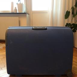 Stor blå resväska i hårdplast  med hjul på.