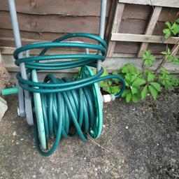Garden hose on stand. not sure how long it is , longer than I've ever needed.