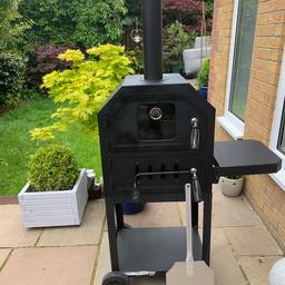 Black Outdoor Pizza oven/Barbecue with Cover and Pizza Peel/Paddle Great Condition will include One Sack Of Kiln Dried Wood .