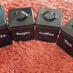 four × kitchen canister set in black. Biscuits, sugar, coffee, tea. all used in fair condition. metal. collection only from Burtonwood, Warrington Cheshire . 