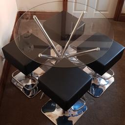 round glass table with chrome base and 4 black and chrome adjustable stools. in excellent condition. like new.