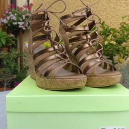 Verkaufe ungetragene Sandaletten mit Keilabsatz. Farbe gold/braun. 
Größe: 38
