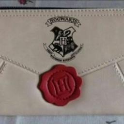 Nuovissimo, mai usato portamonete da donna che riproduce la lettera di Hogwarts della saga Harry Potter con le tasche per documenti e banconote. Scomparto con chiusura a cerniera per le monete.