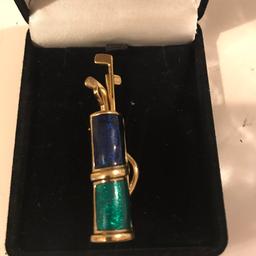 Gold coloured and enamel golf bag and clubs brooch, boxed and in very good condition feel free to text 07846707391