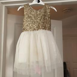 Bought but never worn. 
Gold white dress with heart shape out at the back with a nice pink bow.