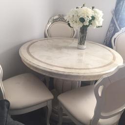 Round Italian table with 4 cream leather chairs  the chairs Are still coverd with plastic they came in when it was new there are a couple of small marks  not really noticeable very good condition £200 buyer must collect no time wasters please