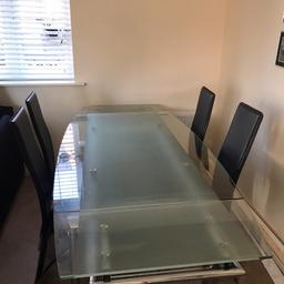 Modern stylish dining room table complete with 4 high back chairs (additional 2 damaged chairs included if wanted). The ends extend to increase size with a clever mechanism that stores the ends away when not in use. Perfect table for that Christmas dinner. Collection in Silsoe