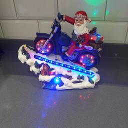 santa on a bike  Christmas decoration, indoor use ,runs on 3 AA batteries,   lights  go round on wheels as if  to make you think the wheels are moving  measurements  are L 32cms x W12 cms  xH 27 cms ,