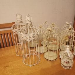 A set of 7 matching, medium sized cream bird cages. 2 large off white cages. 2 small cages. Decorative with space for candles. Used for wedding table decoration as seen in photos. They were left outside over the summer so not perfect. Some tiny bits of rust. Could be sprayed. Pick up or drop off locally. One of the medium cages is slightly dented. They would still be beautiful for centre pieces and looked amazing at our wedding and my nieces christening.