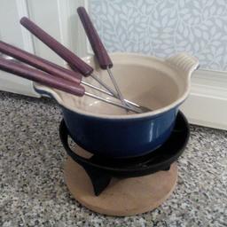 Small blue fondue set with 4 forks, cast iron stand and wooden base. Never used