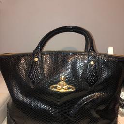 Genuine Vivienne Westwood snake print black handbag. Comes as it is, used regularly but in good condition still. Also comes with additional strap to use on your shoulder. Can deliver if local/for fuel.