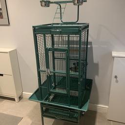Large green wrought iron bird cage complete with play stand. Incorporates 4 bowls 2 inside cage and 2 on play stand. It has a feeder catcher to eliminate mess. It measures 64cm x 64cm x 155cm (LxWxH) in very good condition.