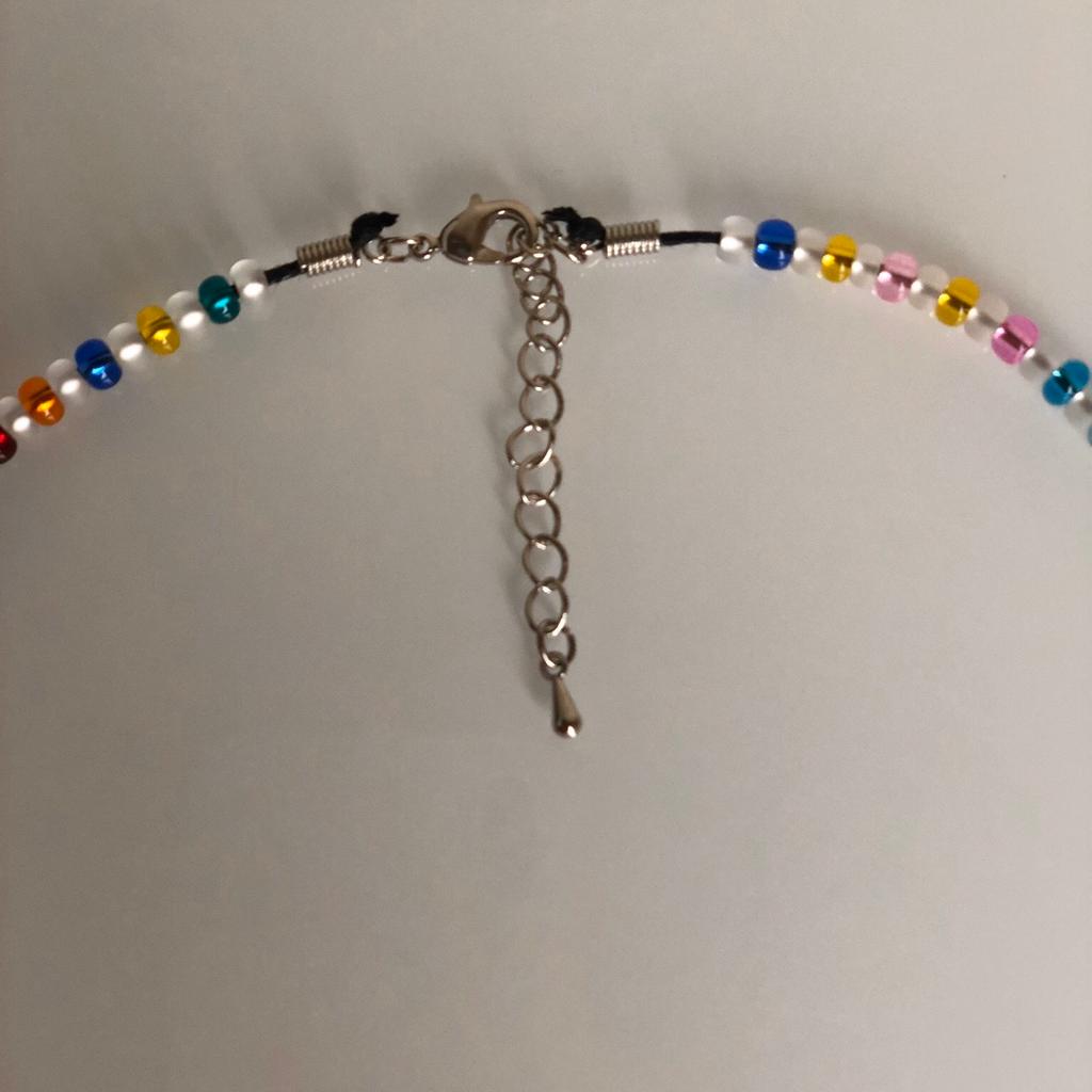 Halskette ca. 63 cm länge , Metall - Perle mit Herz Motiv , Zwischenring rund Crystal und Bunte Perlen , mit verstellbaren Spiralverschluss mit Karabiner .