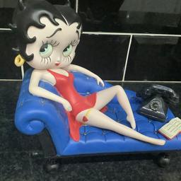 Betty Boop chilling out on her blue chaise launge with old telephone and book.