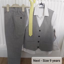 Next three piece suit comprising of grey trousers  & waistcoat & a white long sleeved shirt. Also includes a yellow tie & purple bow tie.

Size 9 years.

In excellent condition, only been worn once.