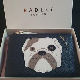 Celebrating Radley's 20th anniversary this English bulldog edition is brand new and boxed.
Grainy leather
Zip-top fastening
+ longer wristlet attachment
Internal zip pocket
Internal pouch
Dust bag included
Perfect gift for dog lovers
Beautiful Christmas gift

delivery options available