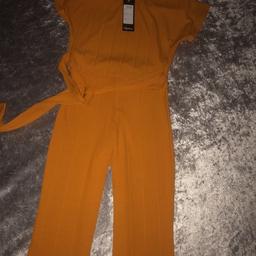 Mustard elastic waist ,long leg pants 9ich wide at bottom pants , ( just right size , not 2 flared) top T-shirt style with long belt attached , lovely suit can be dressed up with a wedge or dressed casual with sandal , still has tags on , fit 8/10   And 10/12 woman’s , collection Kirkby £15 suit