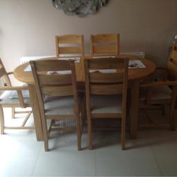 Solid wood Table Oval shape extends.          And six Chairs two main chairs with Arms.            And Four push under chairs cream seats.               All solid wood in NatOak wood. Varner                  Bought from Harvey's furniture store. Payed           £1,129.00.  Will sell £90.00. O.N.O
